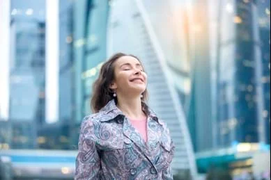 一個女人站在一座城市建築前。