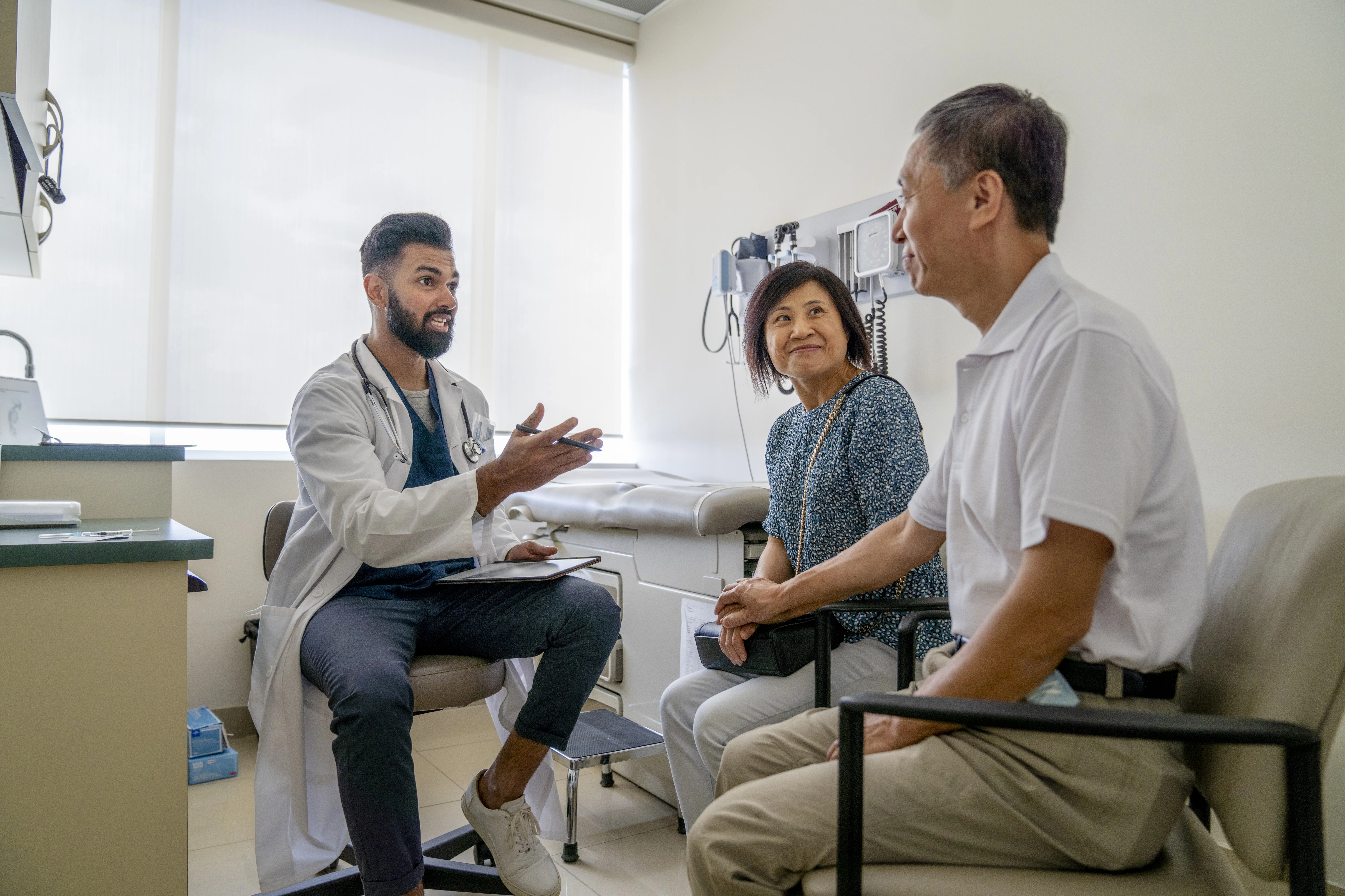 Healthcare professional speaking with two people